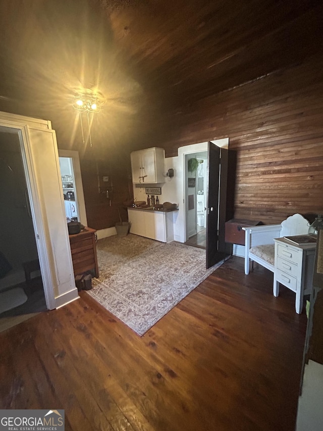 interior space with dark wood-type flooring and wooden walls