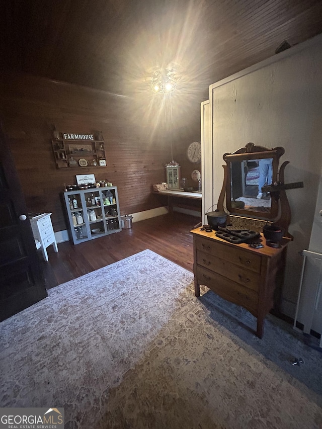 interior space with dark hardwood / wood-style flooring and wooden walls