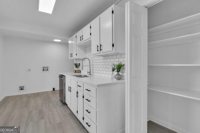 kitchen with dishwasher, sink, light hardwood / wood-style flooring, decorative backsplash, and white cabinets