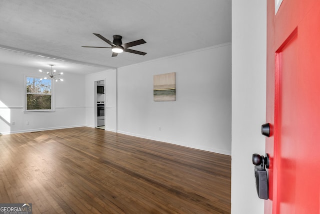 unfurnished living room with ceiling fan with notable chandelier, dark hardwood / wood-style flooring, and ornamental molding