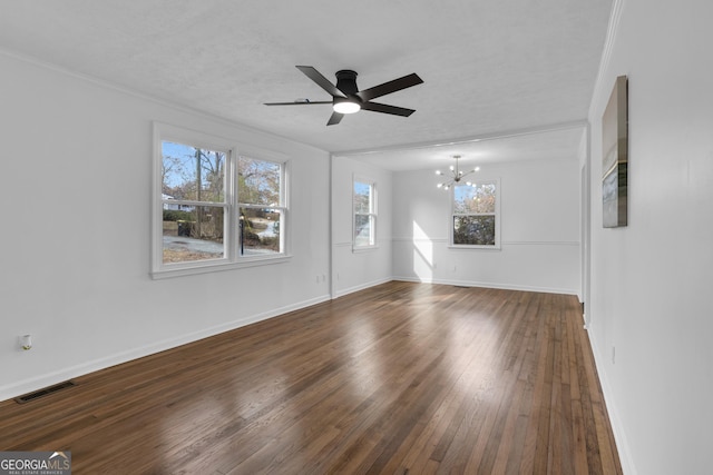 interior space with a textured ceiling, ceiling fan with notable chandelier, ornamental molding, and dark wood-type flooring