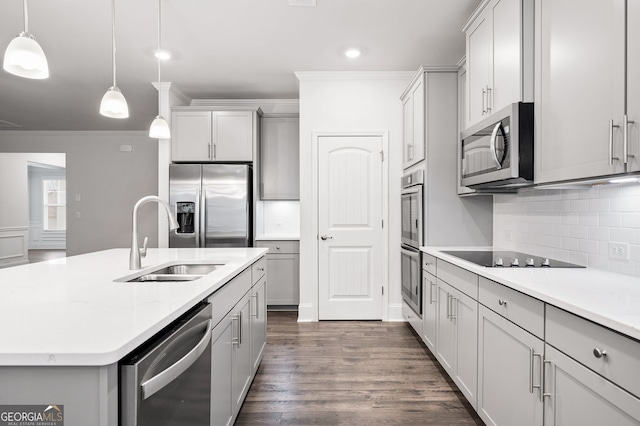 kitchen featuring light stone countertops, appliances with stainless steel finishes, a kitchen island with sink, dark wood-type flooring, and pendant lighting