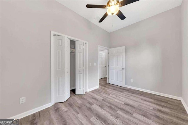 unfurnished bedroom featuring a closet, high vaulted ceiling, light hardwood / wood-style flooring, and ceiling fan