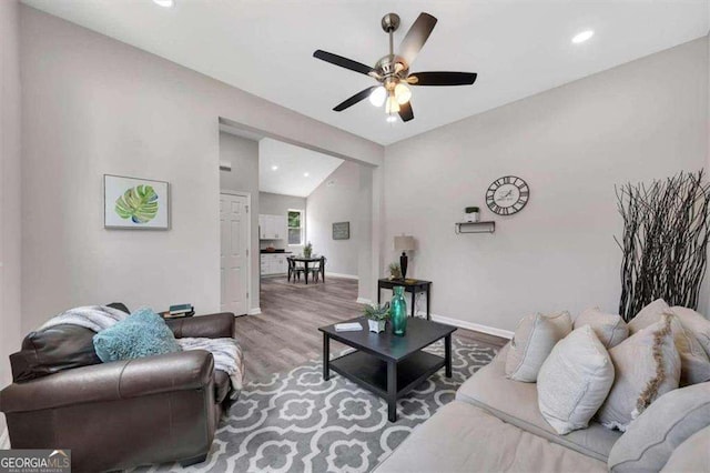 living room featuring hardwood / wood-style flooring, ceiling fan, and lofted ceiling