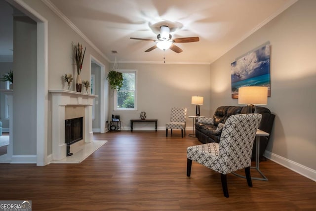 living area with crown molding, dark hardwood / wood-style flooring, ceiling fan, and a premium fireplace