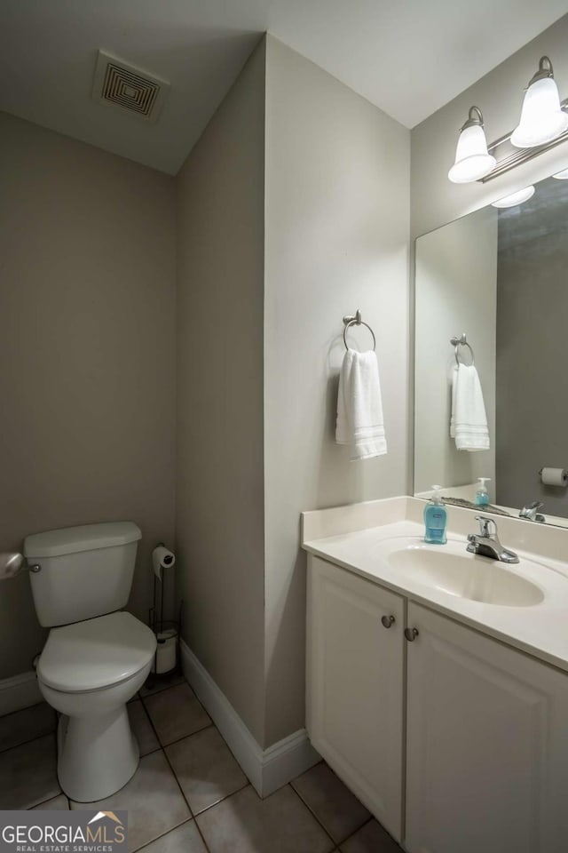 bathroom featuring tile patterned flooring, vanity, and toilet