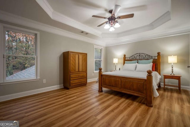 bedroom featuring hardwood / wood-style flooring, ceiling fan, and multiple windows