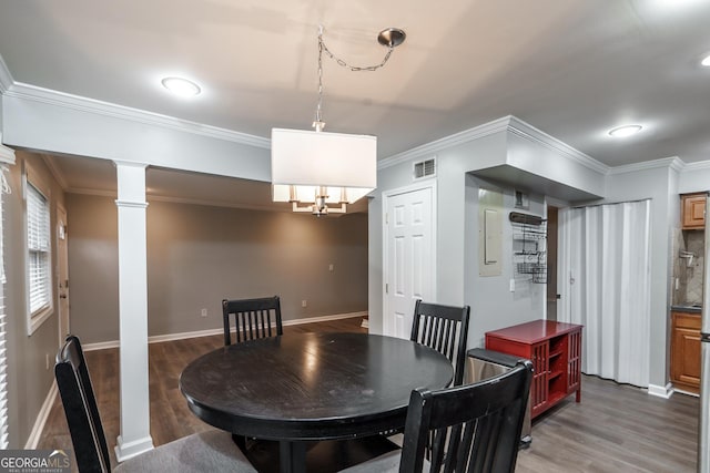 dining space with ornate columns, ornamental molding, and dark wood-type flooring