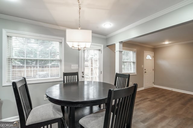 dining space featuring dark hardwood / wood-style flooring, ornamental molding, and ornate columns