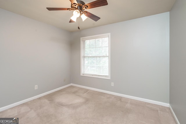 carpeted spare room featuring ceiling fan