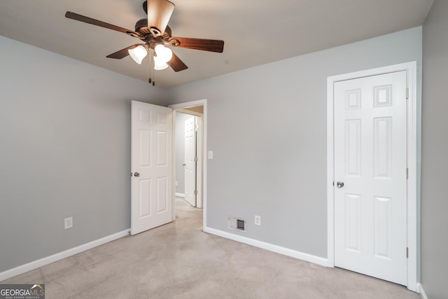 unfurnished bedroom featuring light colored carpet and ceiling fan