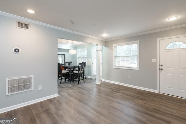 entrance foyer with ornate columns, ornamental molding, and plenty of natural light