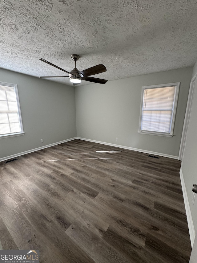 unfurnished room featuring ceiling fan, dark hardwood / wood-style flooring, and a textured ceiling