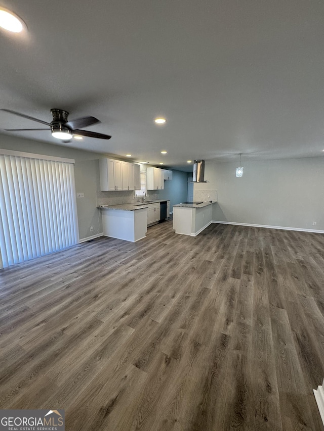 unfurnished living room featuring ceiling fan, sink, and dark wood-type flooring