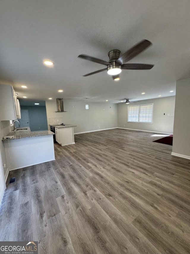 unfurnished living room with ceiling fan, dark hardwood / wood-style flooring, and sink