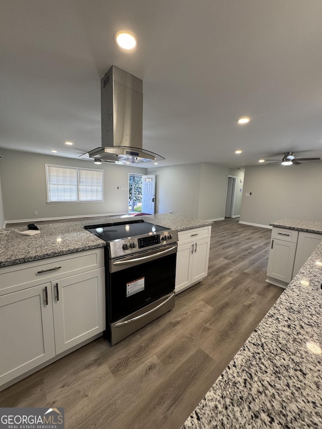 kitchen featuring white cabinetry, light stone countertops, dark hardwood / wood-style flooring, extractor fan, and stainless steel electric stove