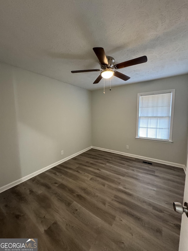 unfurnished room featuring a textured ceiling, ceiling fan, and dark wood-type flooring