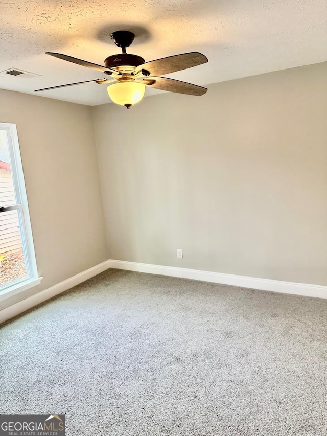 unfurnished room with carpet flooring, a textured ceiling, and ceiling fan