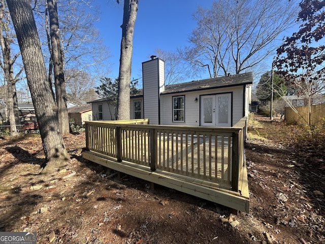 rear view of house with a wooden deck and french doors