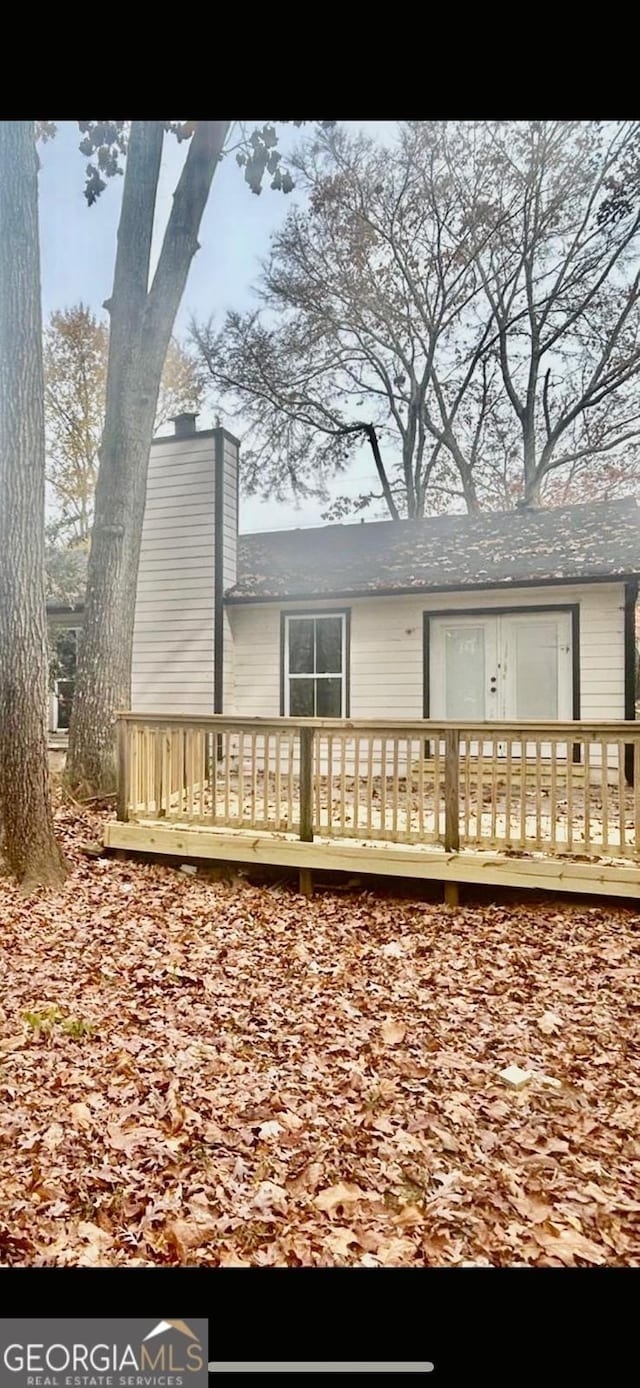 rear view of property with a wooden deck