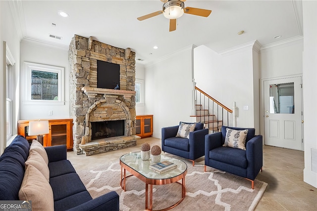 living room with ornamental molding, ceiling fan, and a fireplace