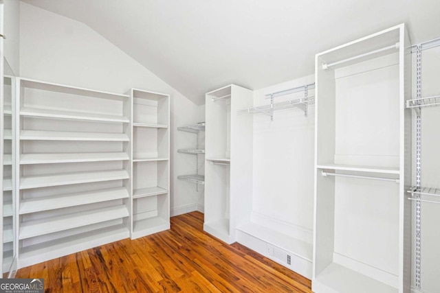 walk in closet featuring vaulted ceiling and hardwood / wood-style floors