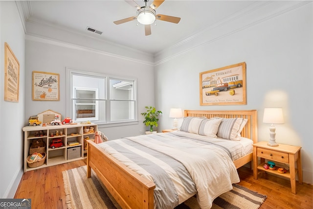 bedroom featuring ornamental molding, ceiling fan, and light wood-type flooring