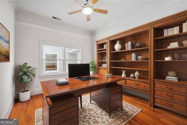 office area featuring ceiling fan, ornamental molding, and light wood-type flooring