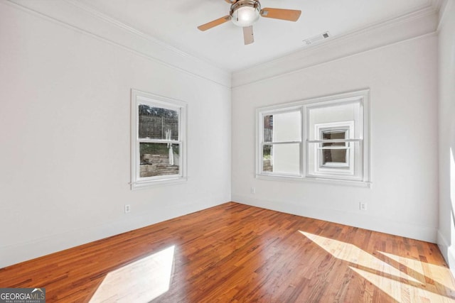 empty room featuring hardwood / wood-style flooring, crown molding, and ceiling fan