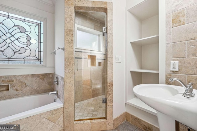 bathroom featuring separate shower and tub, sink, and built in shelves