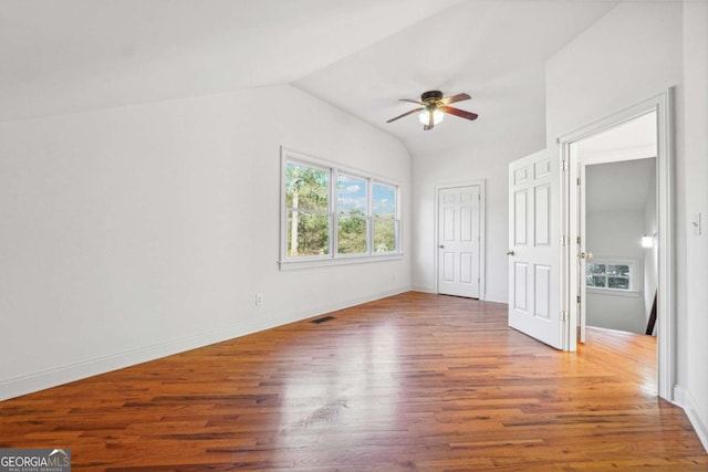 unfurnished bedroom featuring ceiling fan, wood-type flooring, and vaulted ceiling