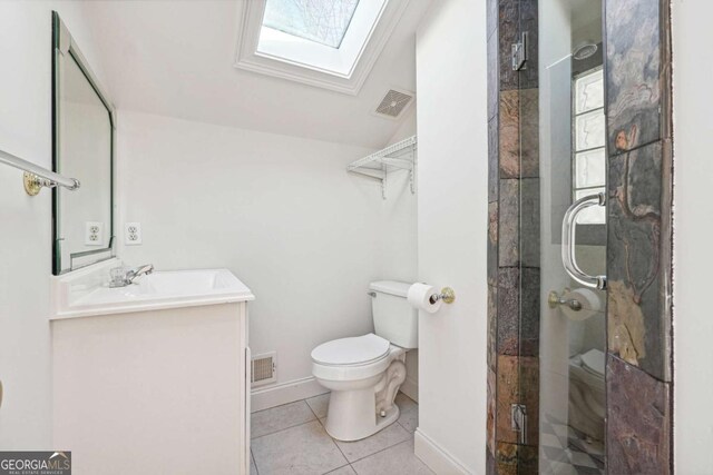 bathroom with vaulted ceiling with skylight, a shower with shower door, vanity, toilet, and tile patterned floors