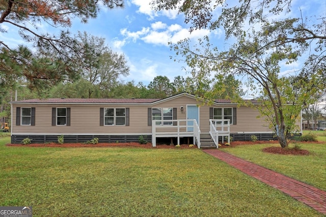 manufactured / mobile home featuring a deck and a front yard