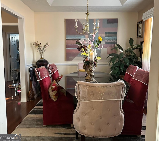 dining area with a notable chandelier and dark hardwood / wood-style floors