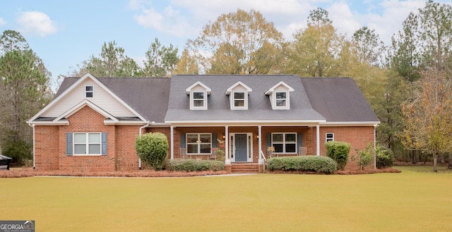 new england style home with covered porch and a front yard