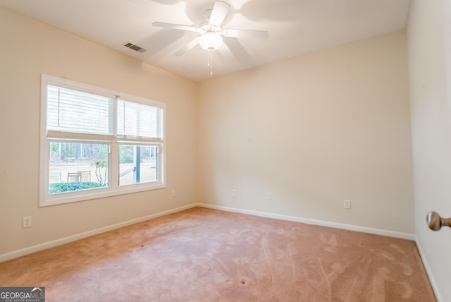 spare room with ceiling fan and light colored carpet