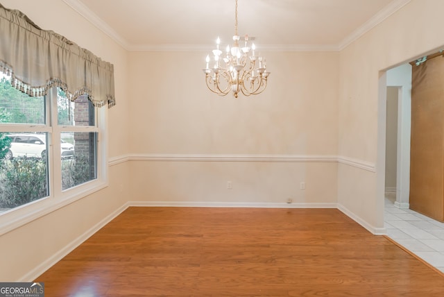 unfurnished dining area with hardwood / wood-style floors, ornamental molding, and an inviting chandelier