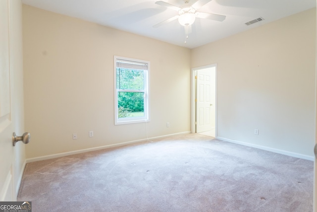 spare room featuring light carpet and ceiling fan