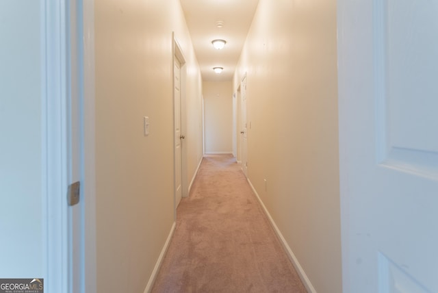 hall with light colored carpet