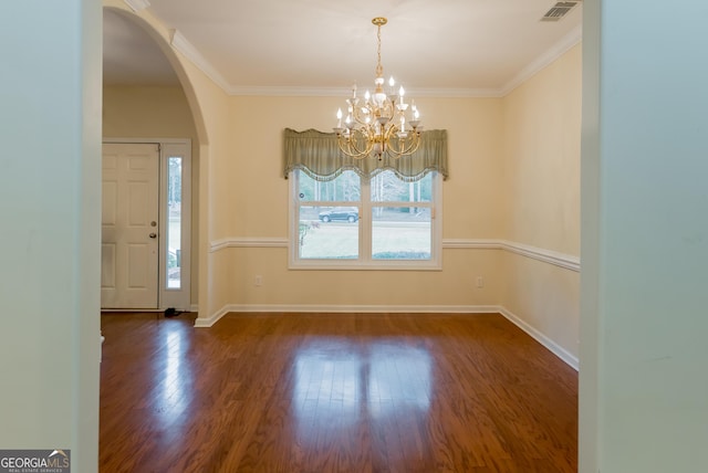 interior space featuring dark hardwood / wood-style flooring, ornamental molding, and an inviting chandelier