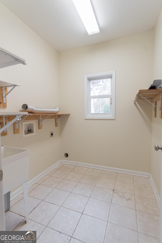 washroom with washer hookup, electric dryer hookup, and light tile patterned flooring