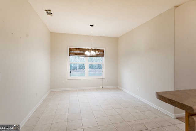 unfurnished dining area featuring light tile patterned floors and an inviting chandelier