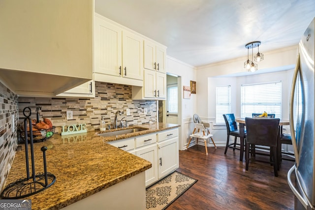 kitchen featuring white cabinetry, sink, dark hardwood / wood-style flooring, stainless steel fridge, and pendant lighting