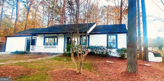 ranch-style house with covered porch and a storage unit