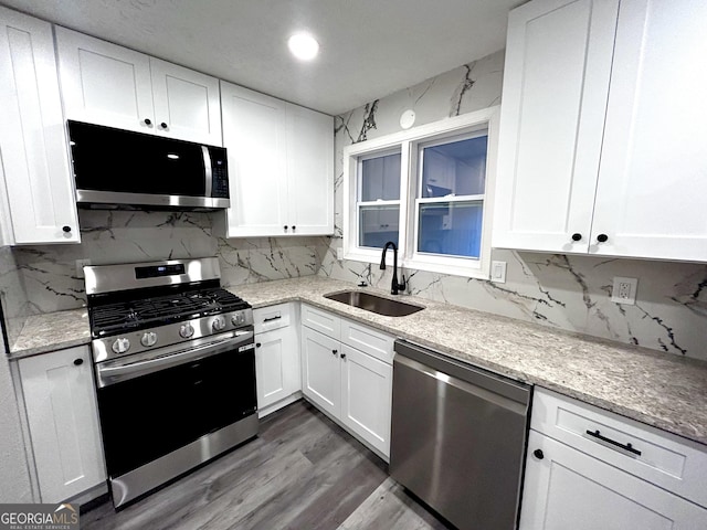 kitchen with white cabinets, dark hardwood / wood-style flooring, stainless steel appliances, and sink