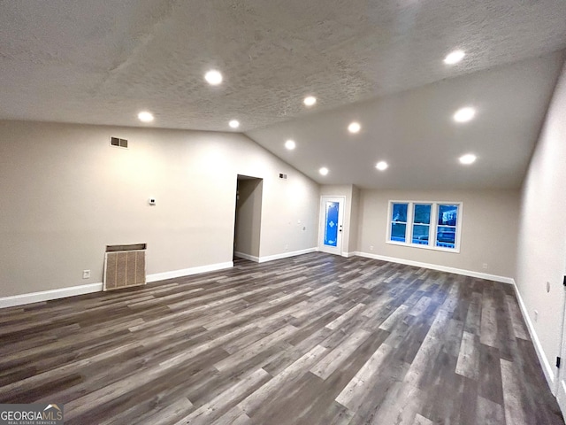 unfurnished living room featuring a textured ceiling, dark hardwood / wood-style floors, and lofted ceiling