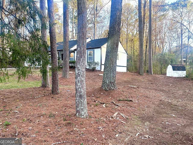 view of side of home featuring a storage shed