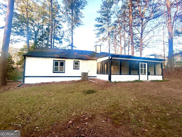 view of front of home featuring a sunroom, central AC, and a front lawn