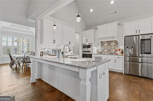 kitchen featuring dark hardwood / wood-style flooring, stainless steel appliances, white cabinetry, and light stone counters