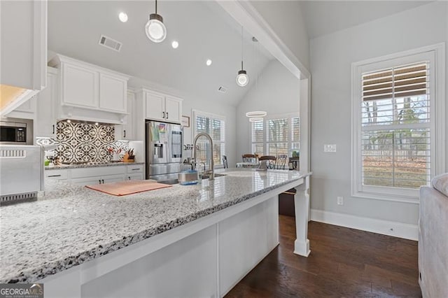 kitchen featuring a healthy amount of sunlight, white cabinets, and pendant lighting